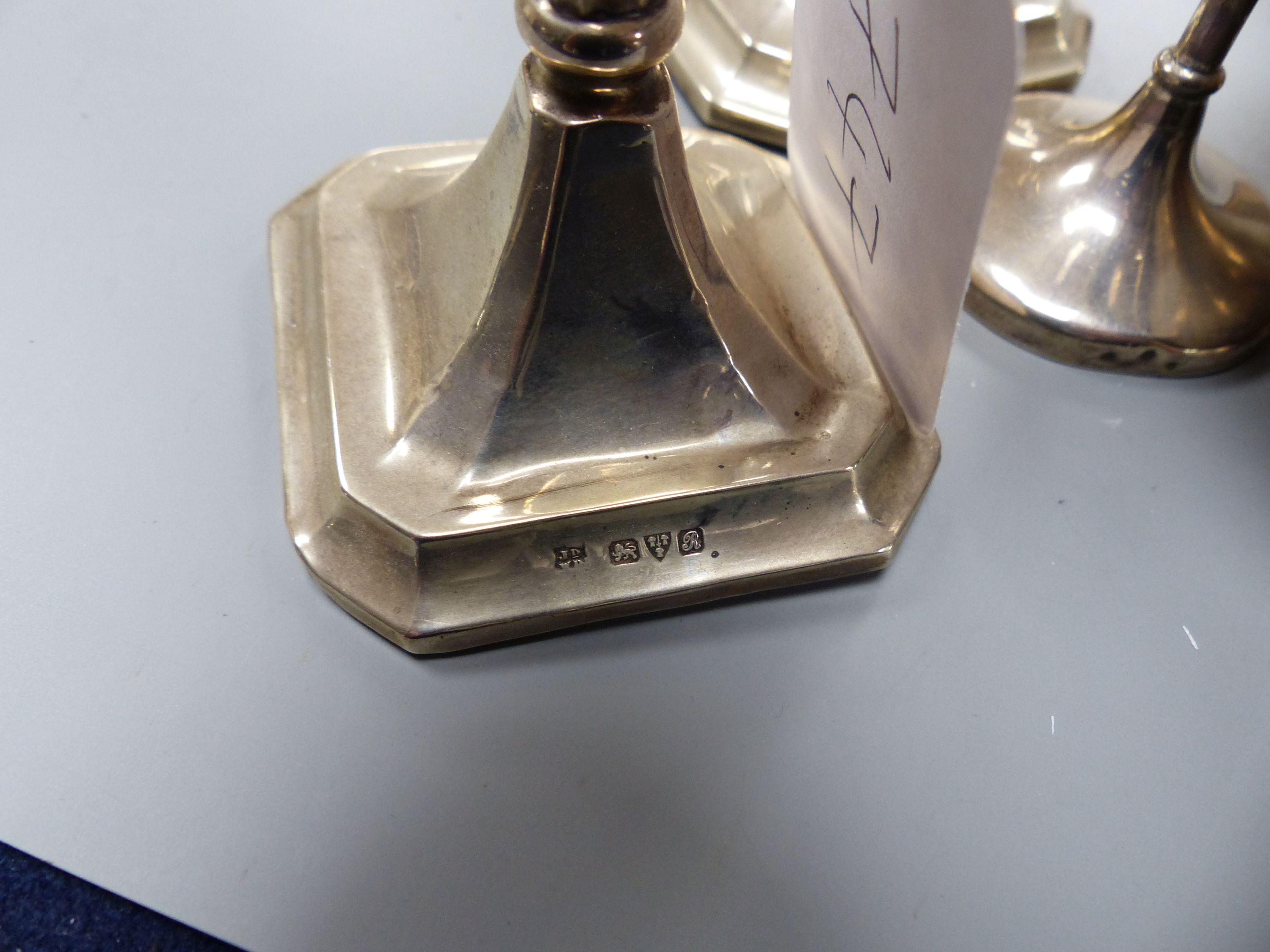 A pair of George V silver mounted candlesticks, 15.2cm, a silver posy vase, silver bowl, silver pierced dish and a 925 inset coin dish.